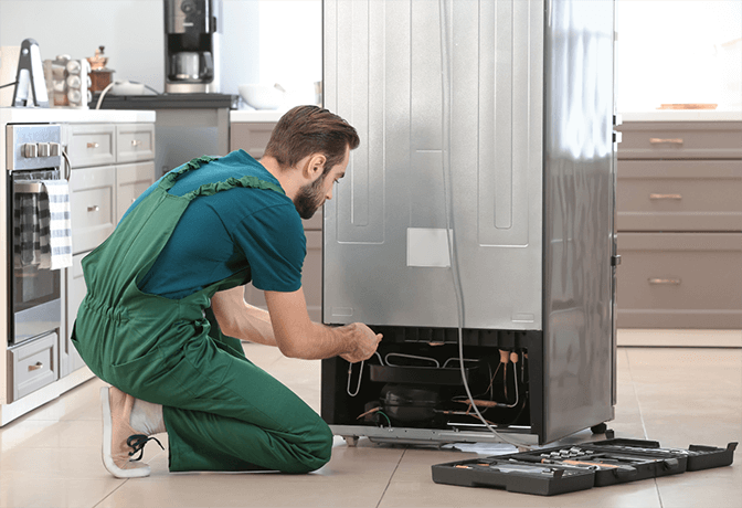 Emergency refrigerator repair service in Abu Dhabi - Abu Dhabi Appliance Repair technician performing diagnostic tests